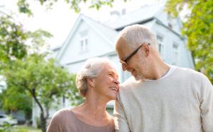 senior couple with reverse mortgage house in background