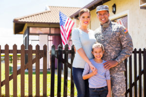 family in front of new house bought with va loan