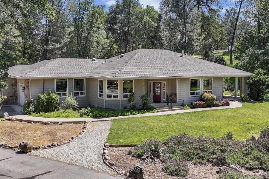 A house with trees behind it and a cute front lawn that was purchased by a traveling nurse with variable contracted income